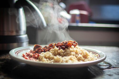 A close-up of steaming rice with beans, captured in warm afternoon light.