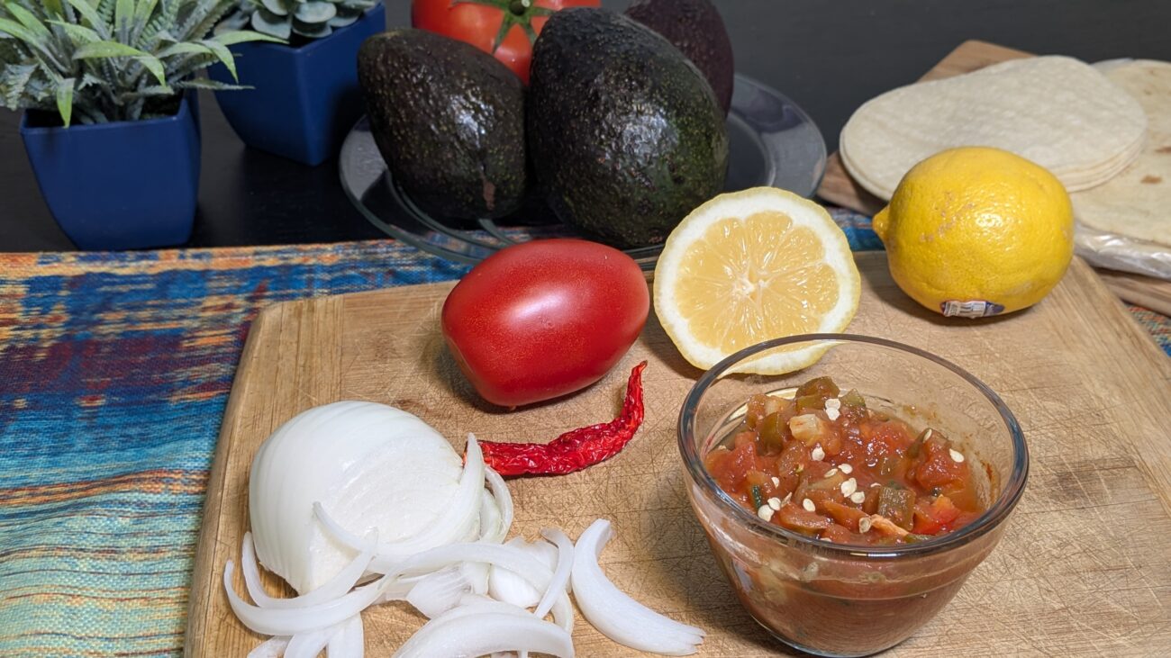 Sensational Salsa with tomatoes, onions, lemon and roasted pepper on a cutting board.