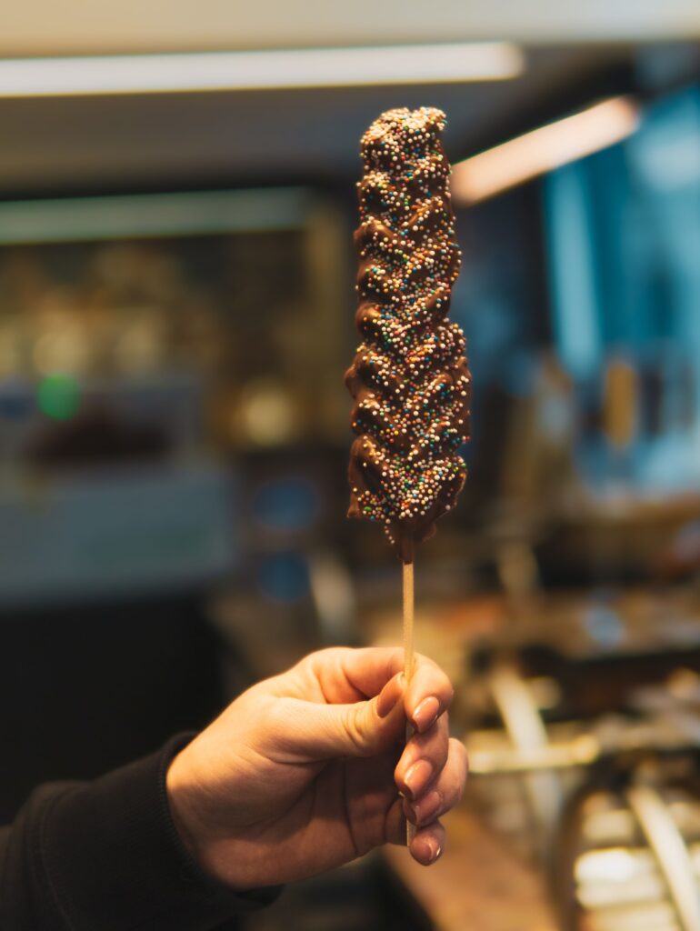 Delicious chocolate-covered treat with colorful sprinkles in Brugge, Belgium.