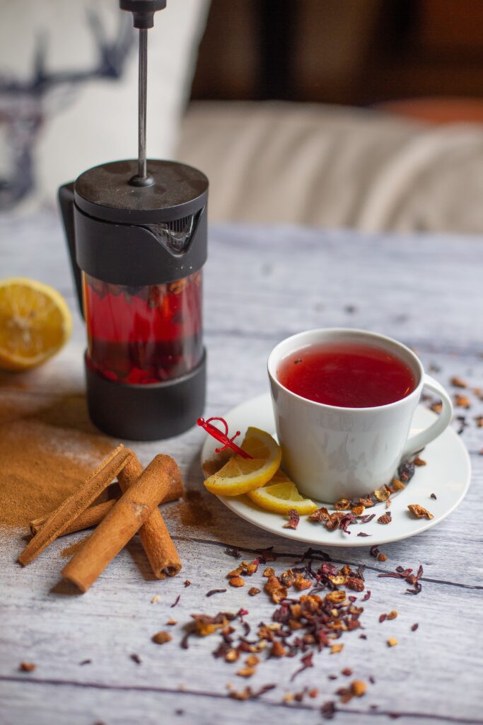 Warm cup of fragrant tea with cinnamon, lemon, and French press on a rustic table. Blackberry Cinnamon Tea for the Sunday Cozi Crossword | by mehmetakifarts via pexels